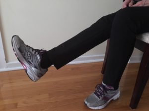 Senior stretching while sitting on chair